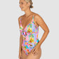 Woman wearing a colorful floral one-piece swimsuit on a light gray background