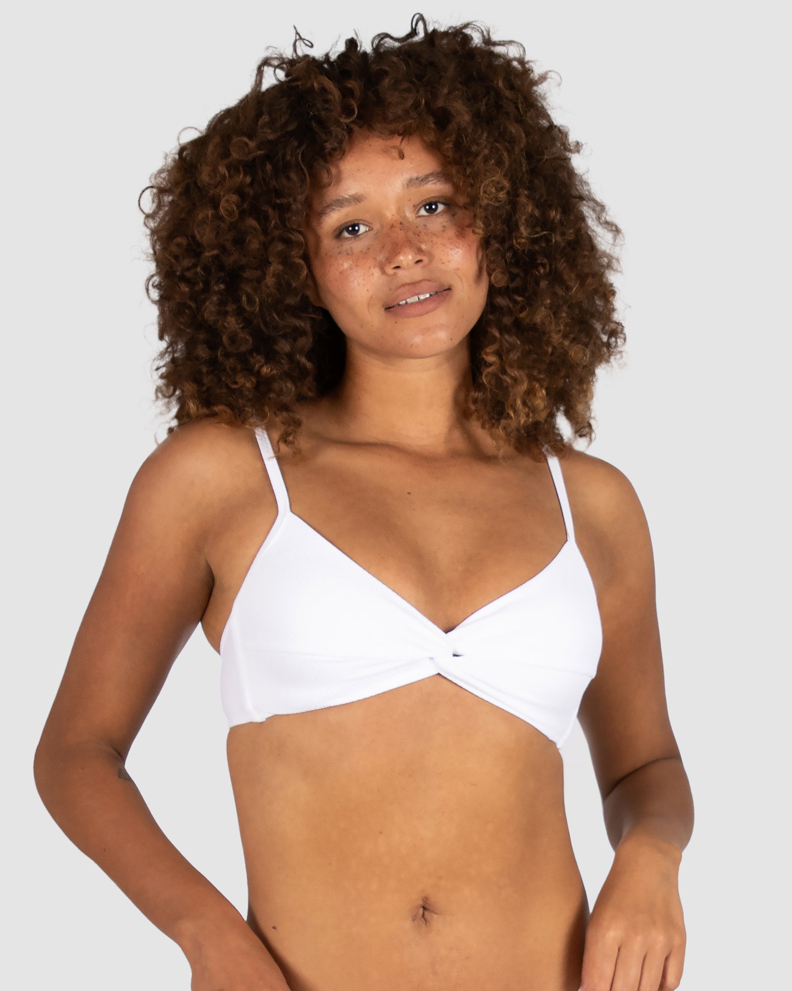 From Australian swimwear brand Baku, the Rococco Multifit Bralette Bikini Bra in White offers a crisp, minimal aesthetic with elegant structure. It features a twist front detail, soft removable cups, adjustable and convertible straps, and a secure clip back closure—all crafted from soft Spanish fabrication.