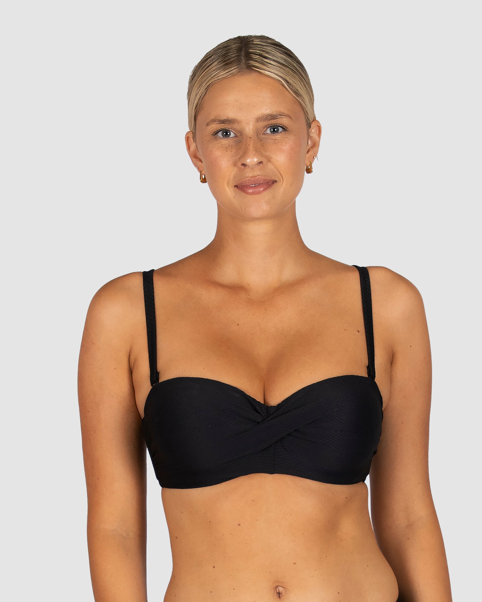 Baku is a premium Australian swimwear brand. The Rococco D/DD Cup Twist Bandeau Bikini Bra in Nero, a classic black, is designed for elegant support and styling flexibility. With moulded cups, side boning, gripper tape, and a secure back clip, this top provides structure and shape for D-DD cups. Wear it with or without straps for a clean, confident silhouette.