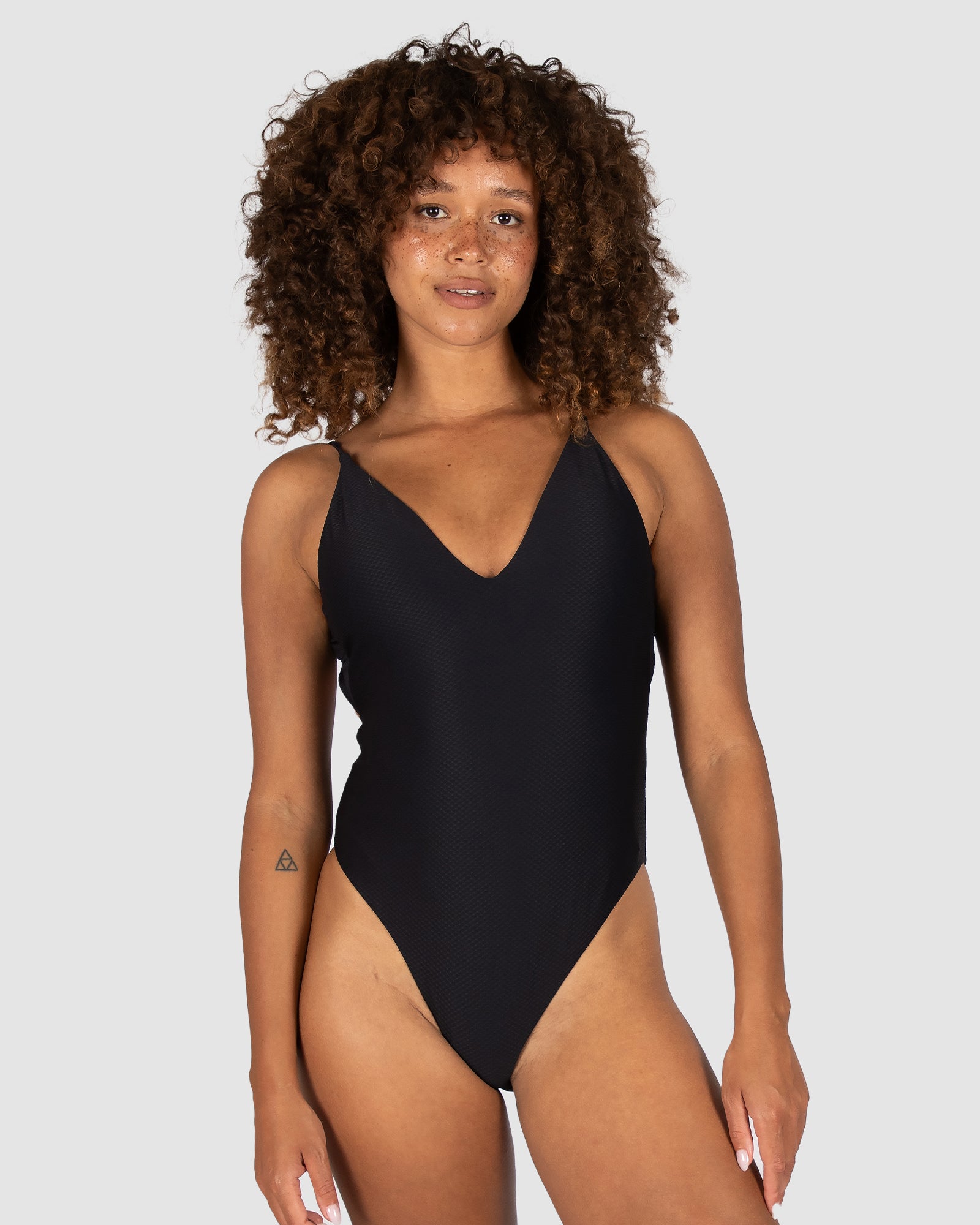 Baku is a premium Australian swimwear brand. The Rococco Deep V Neck Cheeky One Piece in Capri, a vibrant blue shade, is crafted from luxurious Spanish textural fabrication. This style features a plunging neckline, soft removable cups, hidden shelf support, and cheeky bottom coverage. The low back and elegant cross-back straps create a flattering silhouette perfect for poolside or beachside elegance.