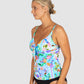 Woman wearing a colorful floral tankini top on a plain background