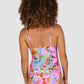 Woman wearing a colorful floral swimsuit on a plain background