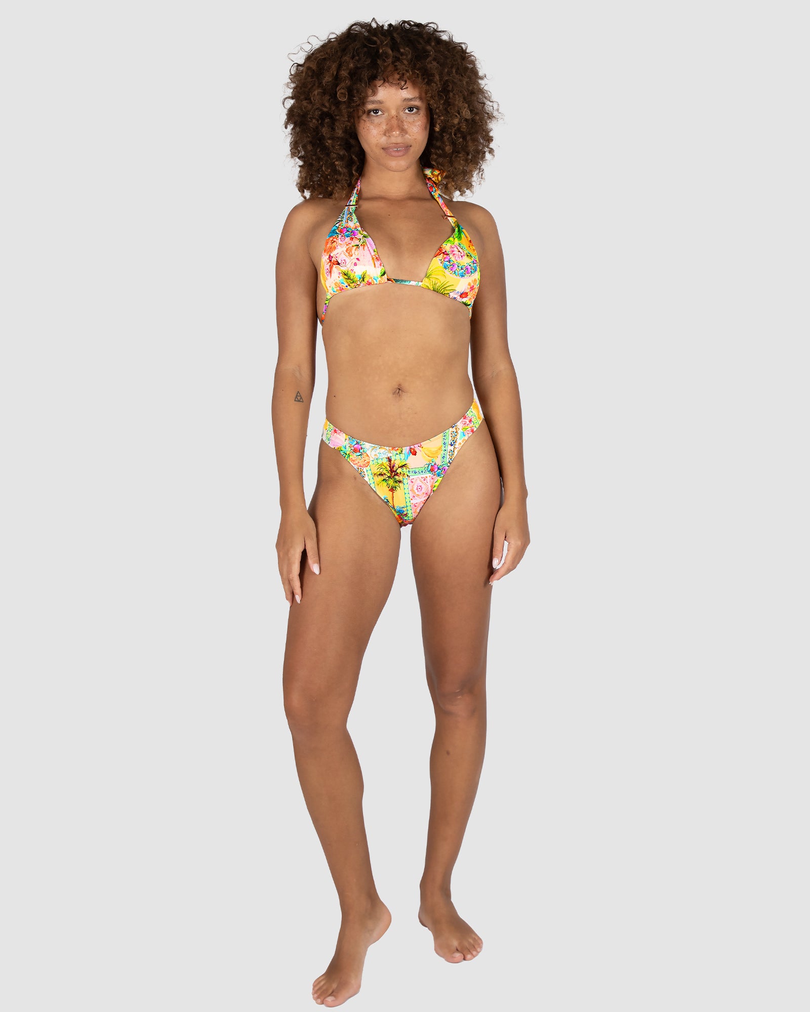 Woman wearing a colorful floral bikini set on a white background