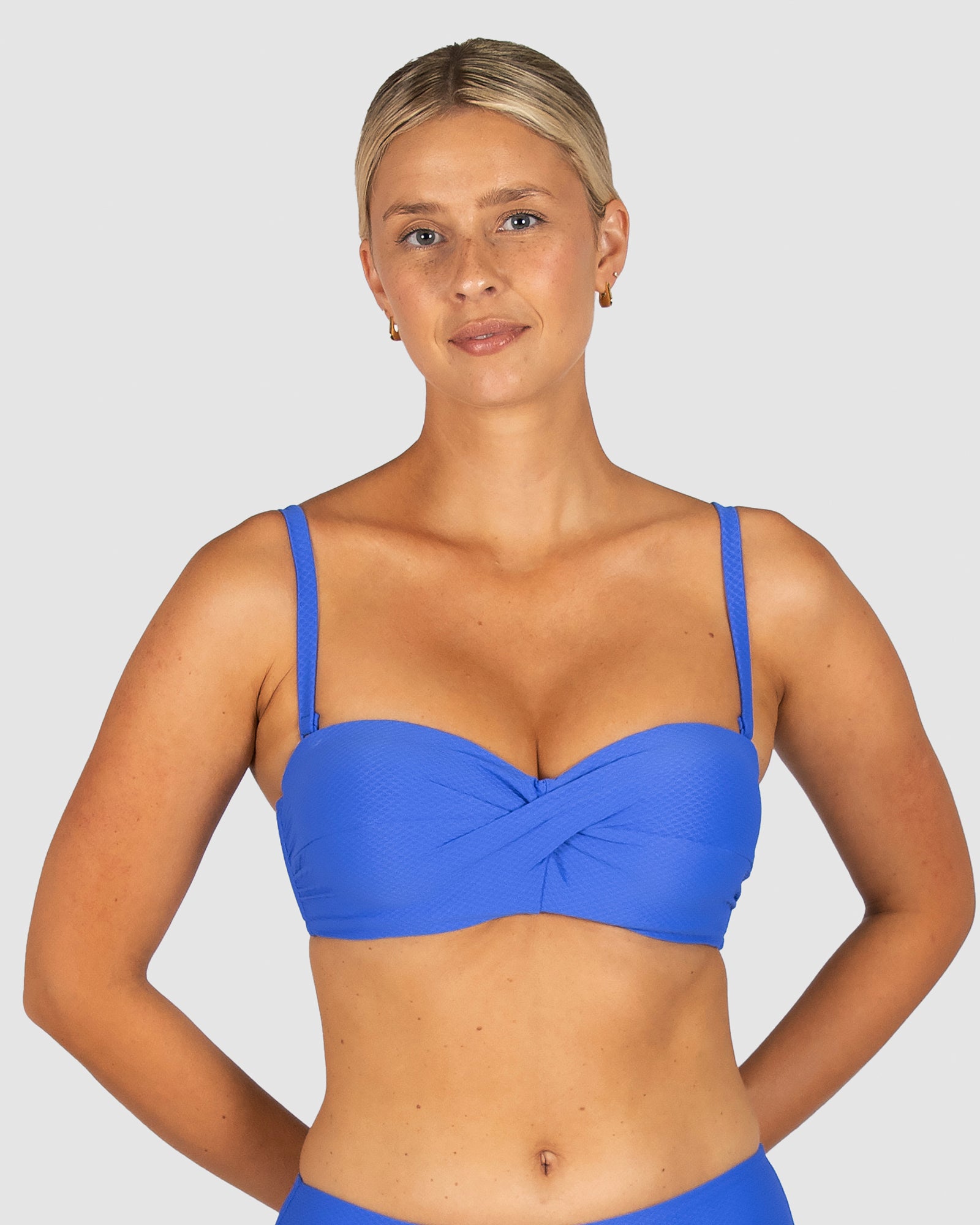 Baku is a premium Australian swimwear brand. The Rococco D/DD Cup Twist Bandeau Bikini Bra in Electric, a bold cobalt blue, offers sculpted shaping and versatile styling. Featuring moulded cups, side boning, gripper tape, and a back clip, it delivers support and structure. Removable and adjustable straps allow it to be worn strapless for a sleek beach look.