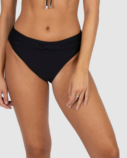 Designed in Australia, the Rococco Cabana Pant Bikini Bottom in Nero delivers timeless elegance in classic black. Made from luxury Spanish textured fabric, it features a twist belt detail, mid-rise fit, regular bottom coverage, and tummy control with power mesh for a flattering silhouette.