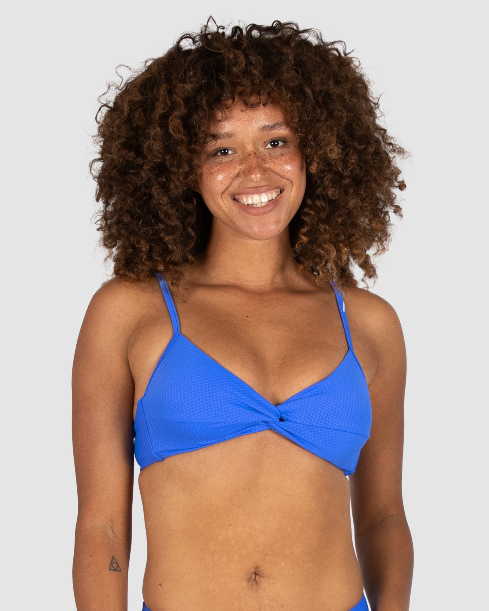 Designed in Australia, the Rococco Multifit Bralette Bikini Bra in Electric brings bold cobalt blue colour to a supportive bralette silhouette. Made from buttery Spanish textural fabric, it features a twist detail, removable soft cups, convertible straps, and a clip back for flexible, comfortable wear.