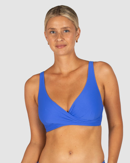 Baku is a premium Australian swimwear brand. The Rococco D-E Cup Wrap Bikini Bra Top in Electric, a striking cobalt blue, blends vibrant colour with supportive design. Made from luxurious Spanish textural fabrication, it features a draped wrap neckline, underwire, boning, and under-bust support. Finished with adjustable, convertible straps and a clip back, it delivers a confident and eye-catching beach look.