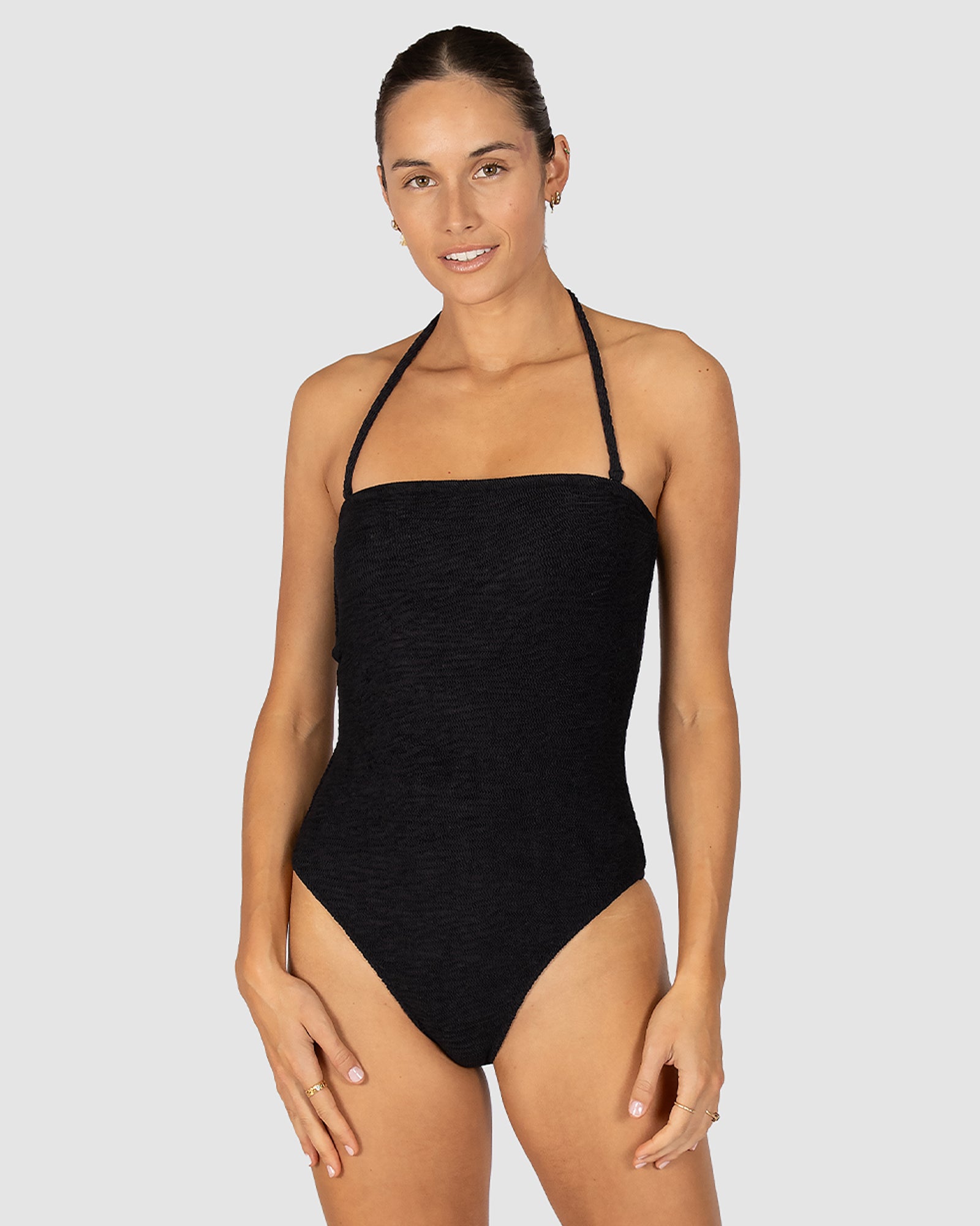 Ibiza Bandeau One Piece in black crinkle fabric designed with removable cups, shelf support, gripper elastic, and clean minimalist finish with higher leg coverage by Australian swimwear brand Baku.