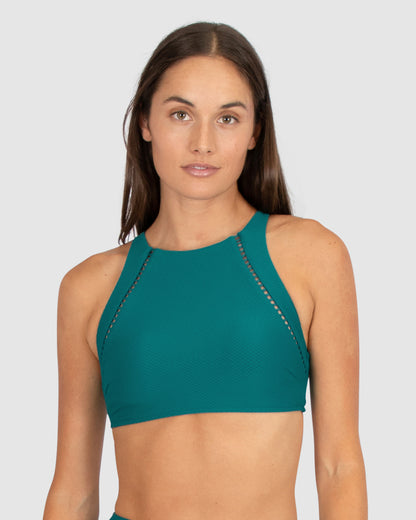 From Baku, a leading name in Australian swimwear, the Rococco High Neck Bra Bikini Top in Jungle delivers a bold deep green hue. Made from soft yet supportive Spanish fabrication, it includes a high neckline with ladder lace trim, removable cups, and convertible straps for styling flexibility.

