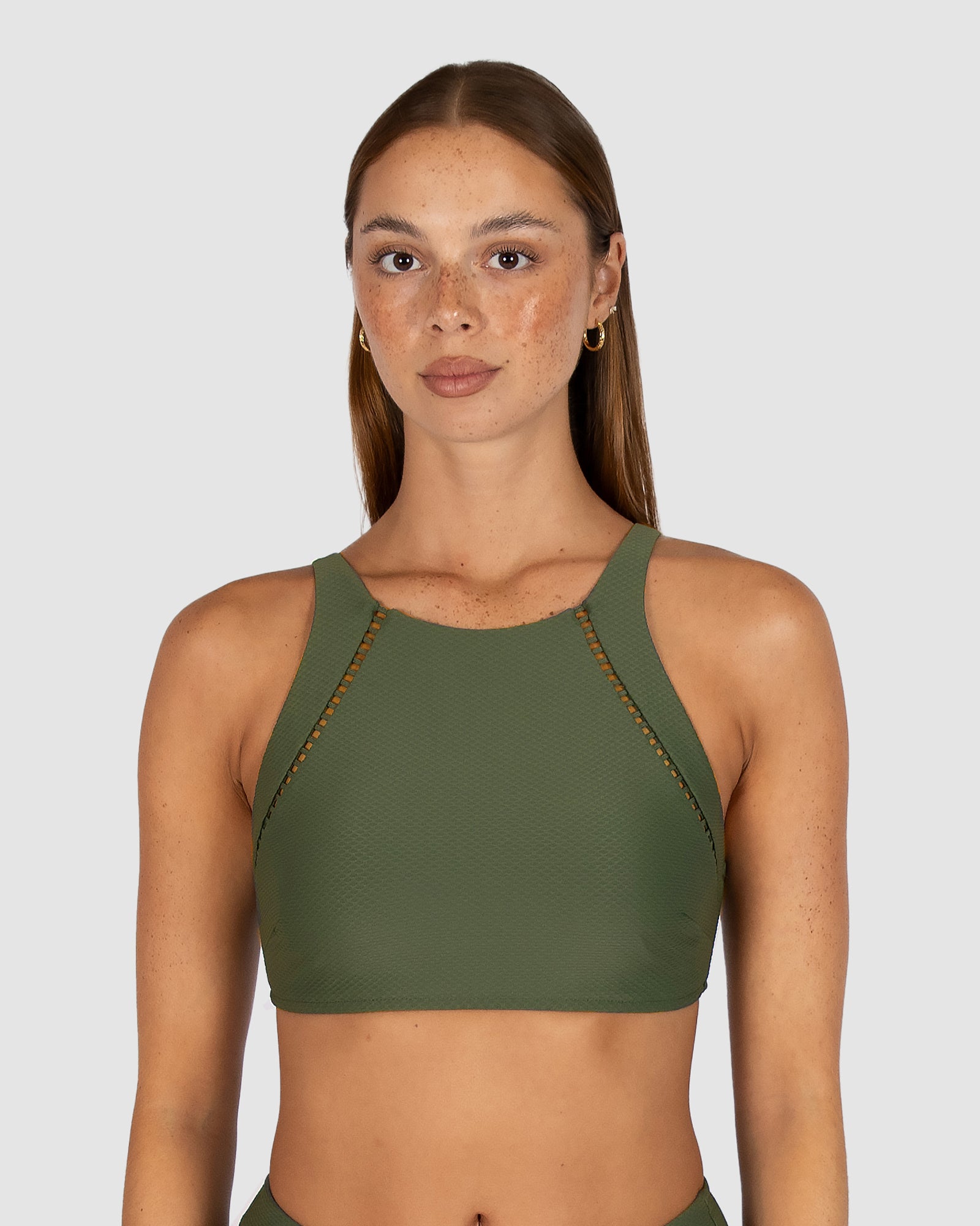 Baku’s Rococco High Neck Bra Bikini Top in Amazon, a muted dark olive green, combines earthy elegance with sculpting support. Crafted from Spanish textural fabrication, it features a high neckline with delicate ladder lace, removable cups, and adjustable convertible straps for a flattering, comfortable fit.

